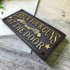 Check Your Guns At The Door Cast Iron Wall Plaque Sign With Antique Finish (7.75" x 3.5") - Jones Peak