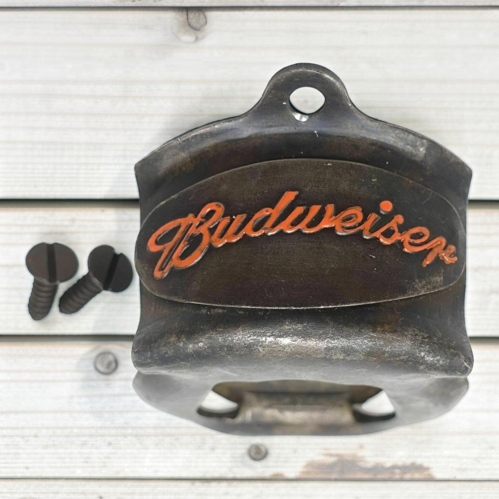 Jones Peak Budweiser 1876 embossed metal wall bottle opener with orange lettering and antique finish.