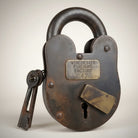 Jones Peak Frontier Arms 1866 cast iron lock with brass tag and keys, distressed finish, 3x5 inches.