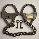 Jones Peak Alcatraz iron handcuffs with chain and two keys, antique finish, decorative reproduction.