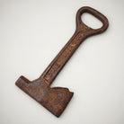 Jones Peak Dixie Hammer & Ax bottle opener, cast iron with antique finish, shaped like a hammer and ax head.