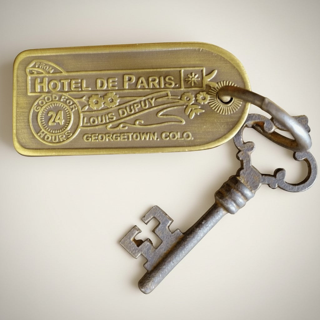 Jones Peak antique brass hotel key tag for Hotel de Paris, Georgetown, Colo. Features "Good for 24 Hours Louis Dupuy" text.